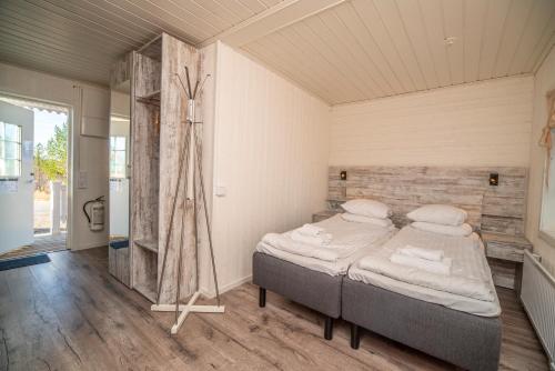 a bedroom with a bed in a room at Aurora Mountain Cabins & Hostel in Lannavaara
