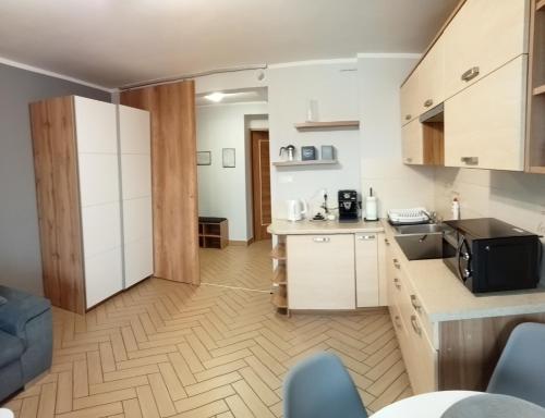a kitchen with white cabinets and a counter top at Way2Jaworzyna in Krynica Zdrój