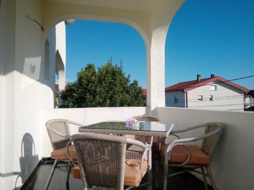 a patio with a table and chairs on a balcony at Hostel Olea in Podgorica