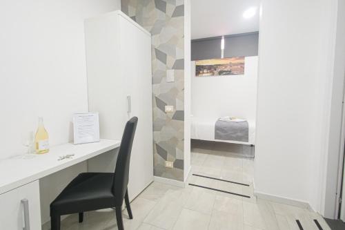 a desk and a chair in a room with a wall at Hotel Terrazza Magenta in Rome