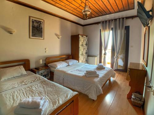 a bedroom with two beds and a window at Hotel Apsis in Emporio
