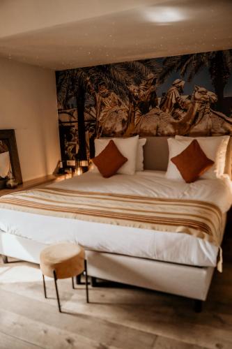 a bedroom with a large bed with a painting on the wall at Boutique Hotel Villa Beukenhof - Leiden in Oegstgeest