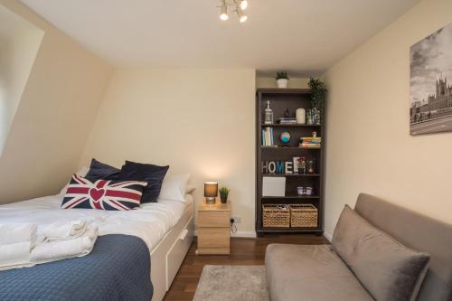 um pequeno quarto com uma cama e um sofá em Pass the Keys Comfy Apartment by Oval Station em Londres