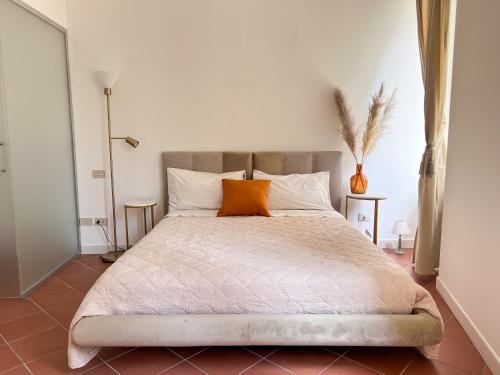 a bedroom with a large bed with an orange pillow at Il Cantuccio di Gioia in Brescia