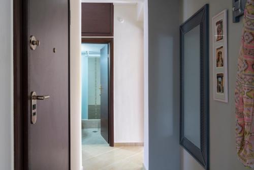un couloir avec une porte et un miroir dans l'établissement Alexandros Maisonettes & Apartments, à Nea Moudania