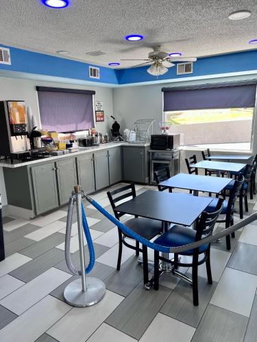 een restaurant met tafels en stoelen en een keuken bij Days Inn by Wyndham Greenville in Greenville