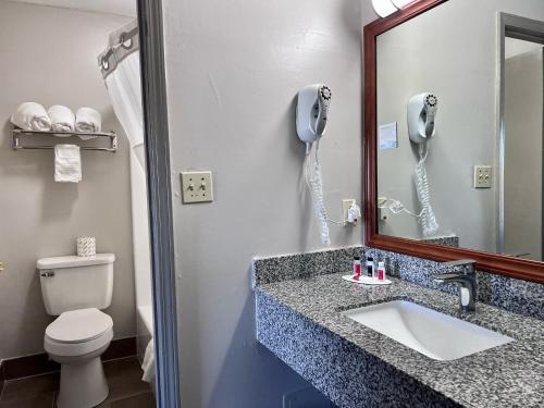 baño con lavabo y teléfono en la pared en Days Inn by Wyndham Greenville, en Greenville