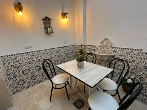 una mesa con sillas y un jarrón de flores. en La Tesela en Priego de Córdoba