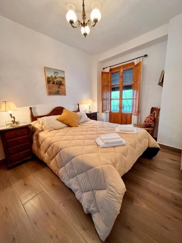 a bedroom with a large bed and a chandelier at La Tesela in Priego de Córdoba
