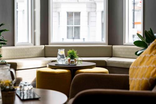 a living room with a couch and a table at Heeton Concept Hotel - Kensington London in London