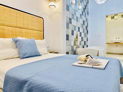 a bedroom with a blue bed with a towel on it at Gerani Deluxe Houses in Astypalaia Town