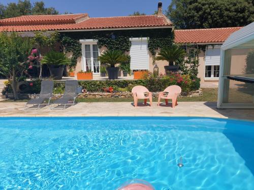 una casa con 2 sillas y una piscina en Petite pause à la campagne, en Sainte-Anastasie-sur-Issole