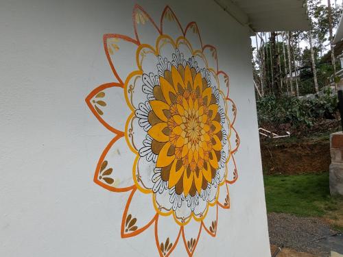 a painting of a flower on a wall at Multiple Stories, Wayanad in Wayanad