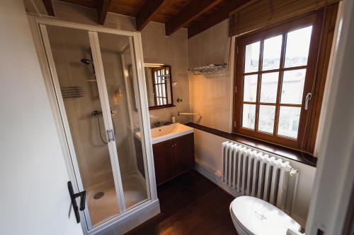 La salle de bains est pourvue d'une douche, d'un lavabo et de toilettes. dans l'établissement Maison d'Hôte la Grange aux Ayres, à Olloix
