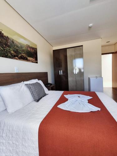 um quarto de hotel com uma cama com uma camisa em Pousada Coqueiral em Aracruz