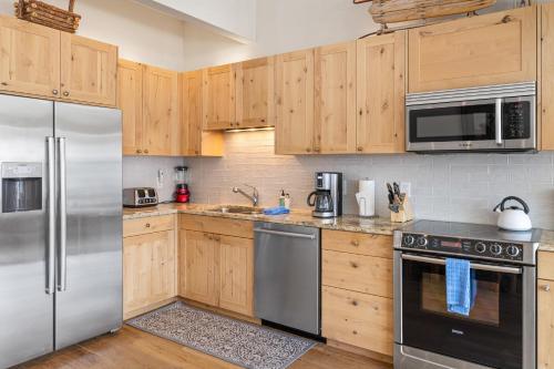 a kitchen with wooden cabinets and stainless steel appliances at West Willow 5 in Telluride