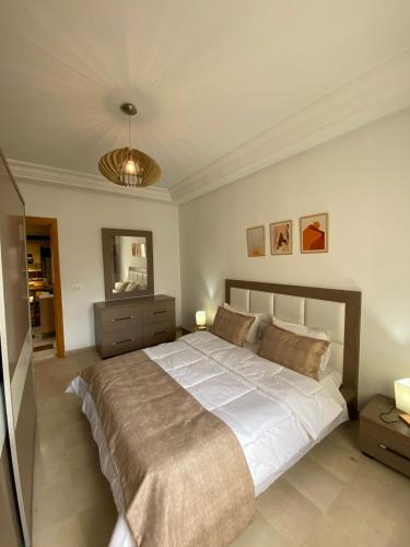 モナスティルにあるAppart calme & chaleureux en résidence près de la merのベッドルーム1室(大型ベッド1台、天井付)