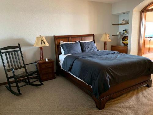 a bedroom with a bed and a chair and two lamps at The Dolphins Ocean Front-Beach 2 BR 2Bth in Rosarito