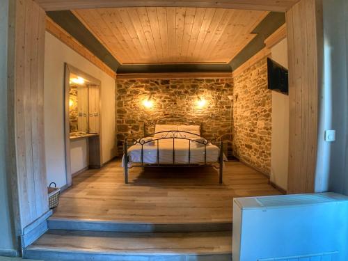 a bedroom with a bed in a stone wall at Hotel Apsis in Emporio