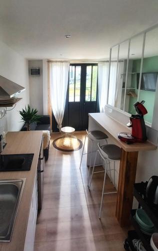 uma cozinha e sala de estar com mesa e cadeiras em Charmant T1 meublé em Mérignac