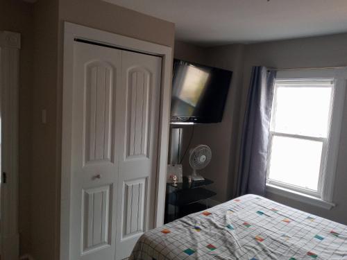 1 dormitorio con 1 cama, TV y puerta en Private Room AIR BNB, en Peterborough