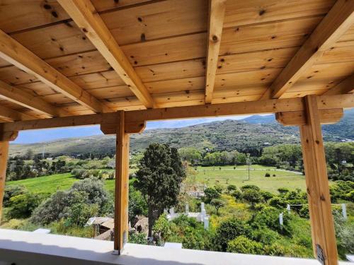 a view from the porch of a house with a wooden ceiling at Stellinas Pretty House in Andros