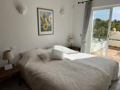 a bedroom with a bed and a large window at 233 Casa Galo Verde Apartments in Porches