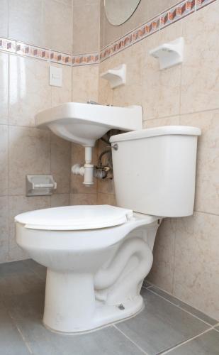 a bathroom with a white toilet and a sink at Hotel Esperanza, Oaxaca Centro in Oaxaca City