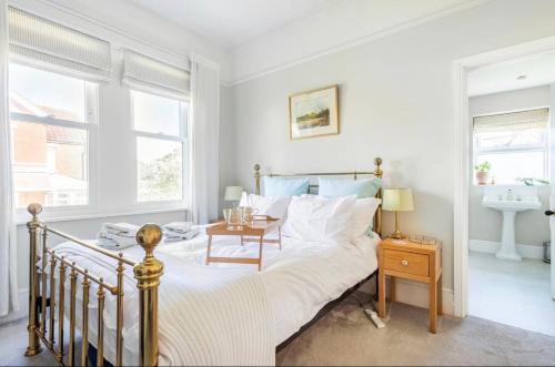 a bedroom with a bed with a table and a sink at Hedgebank in Exmouth