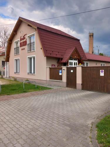 a house with a brick driveway in front of it at Kata Panzió in Oroszlány