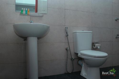 a bathroom with a toilet and a sink at Reecha Organic Resort Jaffna in Kilinochchi