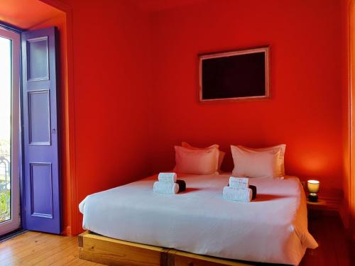 a red bedroom with a bed with two towels on it at Out of the Blue in Ponta Delgada