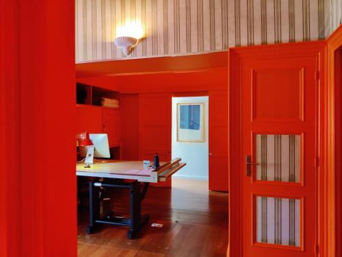 an orange office with a desk and a red door at Out of the Blue in Ponta Delgada