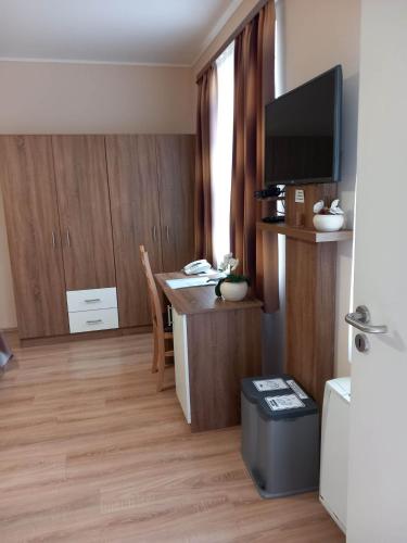 a living room with a desk and a tv in a room at Kata Panzió in Oroszlány