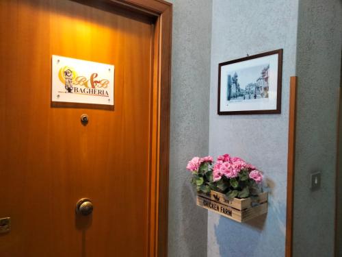 a door with a basket of pink flowers next to it at B&b Bagheria in Bagheria
