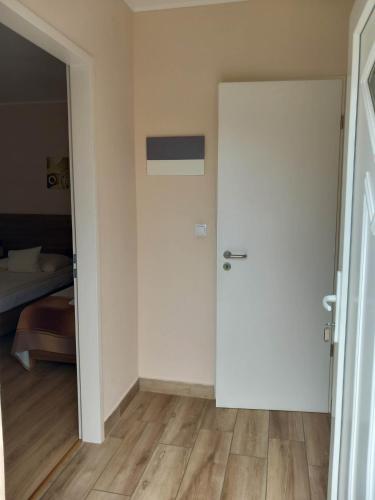 a room with a door and a bedroom with a bed at Kata Panzió in Oroszlány