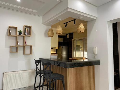 uma cozinha com dois bancos e um balcão num quarto em Appart calme & chaleureux en résidence près de la mer em Monastir