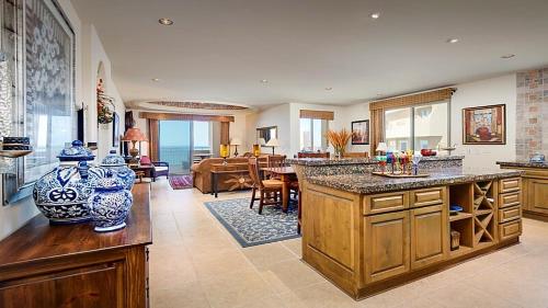 a large kitchen with a table and a living room at Luxury Condo Bella Sirena 805 C , Sandy Beach in Puerto Peñasco