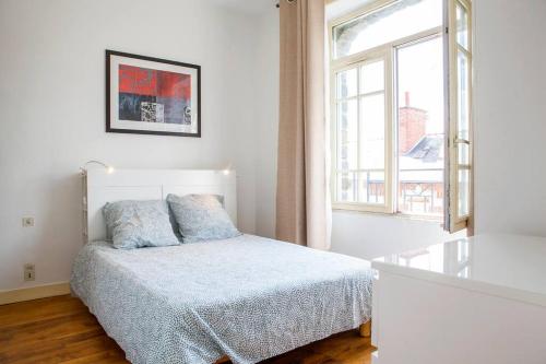 a white bedroom with a bed and a window at Appart Théâtre St Étienne Wi-Fi gratuit in Rennes