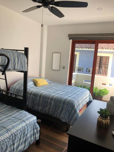 a bedroom with two beds and a ceiling fan at Condominio Alegre Amanecer in Santa Cruz Huatulco