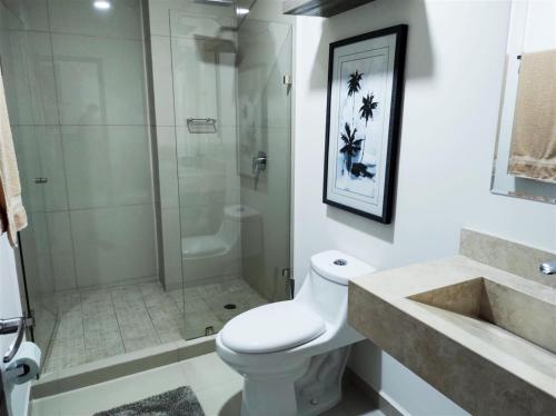 a bathroom with a shower and a toilet and a sink at XMX Pacific Pearl in Mazatlán