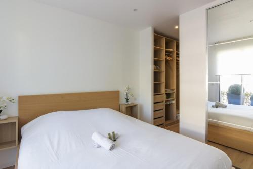 um quarto com uma cama branca com duas velas em Calm and modern flat in Boulogne-Billancourt - Welkeys em Boulogne-Billancourt