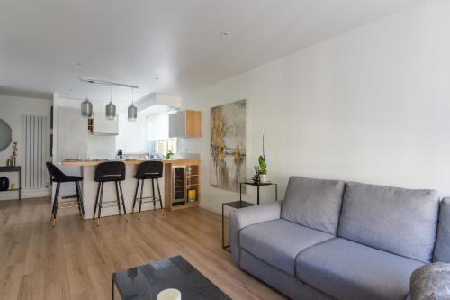 uma sala de estar com um sofá e uma cozinha em Calm and modern flat in Boulogne-Billancourt - Welkeys em Boulogne-Billancourt