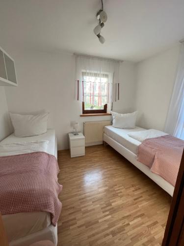 a bedroom with two beds and a window at Ferienwohnung Mittelbiberach in Mittelbiberach