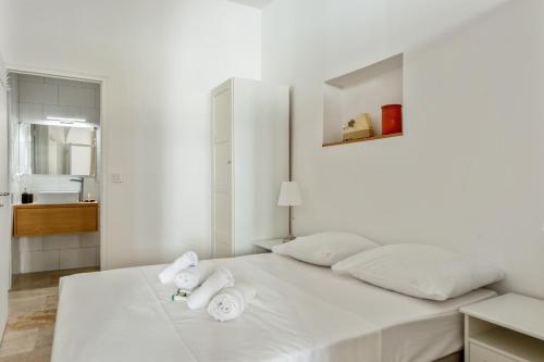 une chambre blanche avec un lit avec des serviettes dessus dans l'établissement Appartement Immaculia - Welkeys, à Cannes