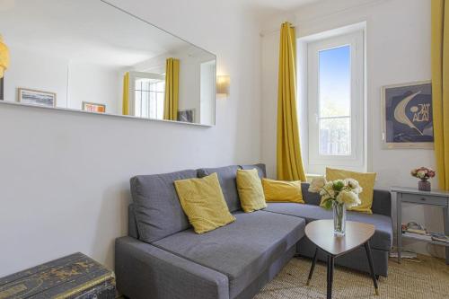 - un salon avec un canapé bleu et des oreillers jaunes dans l'établissement Appartement Yema - Welkeys, à Biarritz