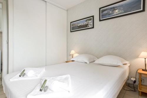 - une chambre avec un lit blanc et 2 oreillers blancs dans l'établissement Appartement Ajar - Welkeys, à Biarritz