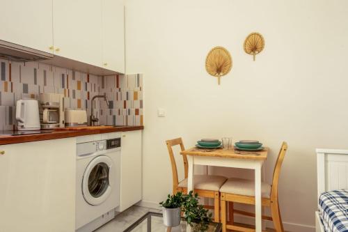 une cuisine avec une table et une machine à laver dans l'établissement Studio du Trousseau - Welkeys, à Paris