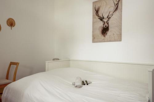 - un lit blanc avec 2 serviettes pliantes dans l'établissement Studio du Trousseau - Welkeys, à Paris