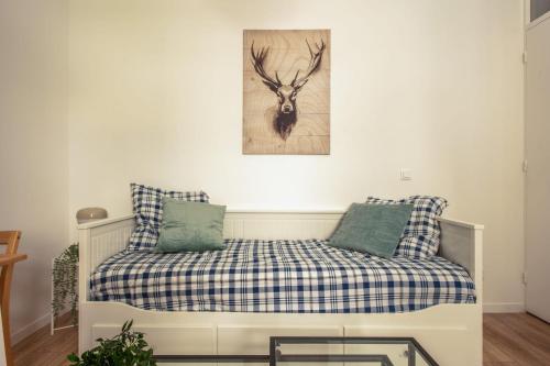 un lit avec deux oreillers et un tableau au mur dans l'établissement Studio du Trousseau - Welkeys, à Paris